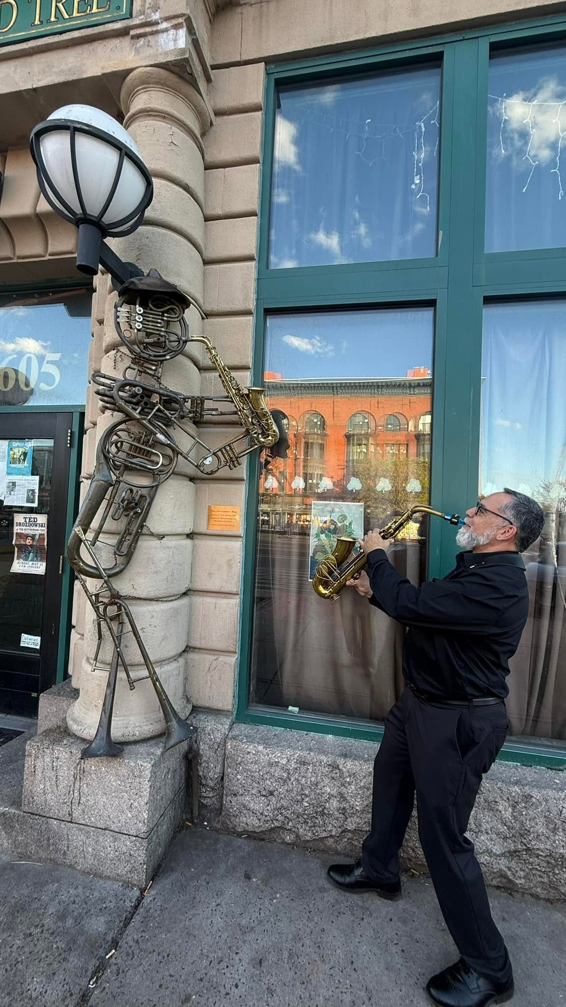 Steve Moran dueling a saxophone-playing statue outside the Buttonwood Tree